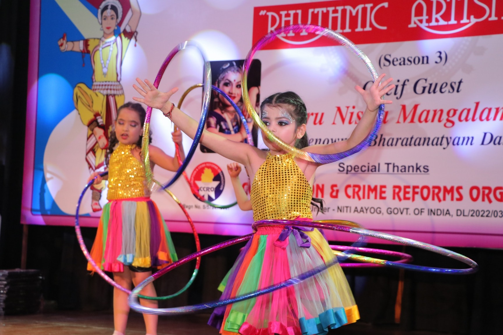 Two young students performing a hula hoop act on stage at Rhythmic Artistika